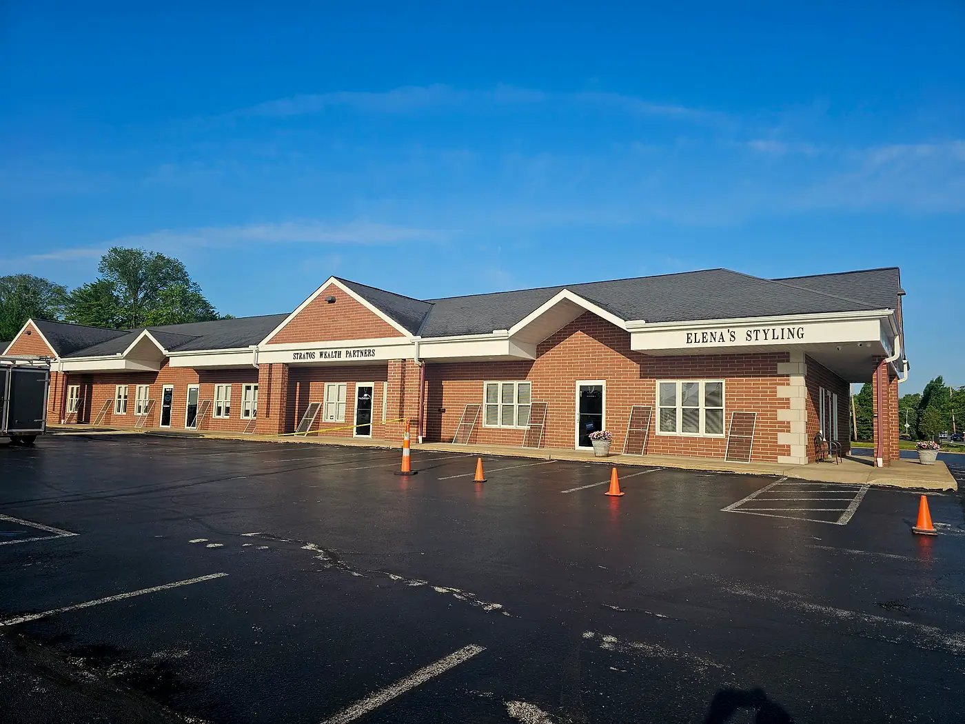 Brick office plaza with a freshly washed parking lot under a clear blue sky