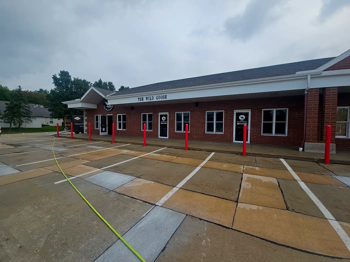 Brick strip plaza with traffic cones set out on a wet, freshly washed parking lot