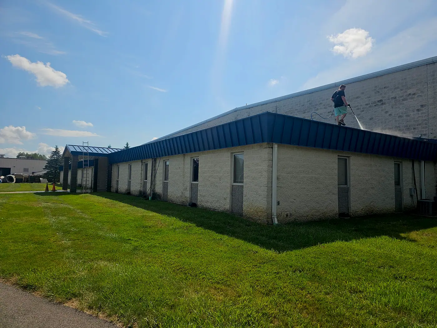 Industrial building with a blue roof beside a trimmed lawn