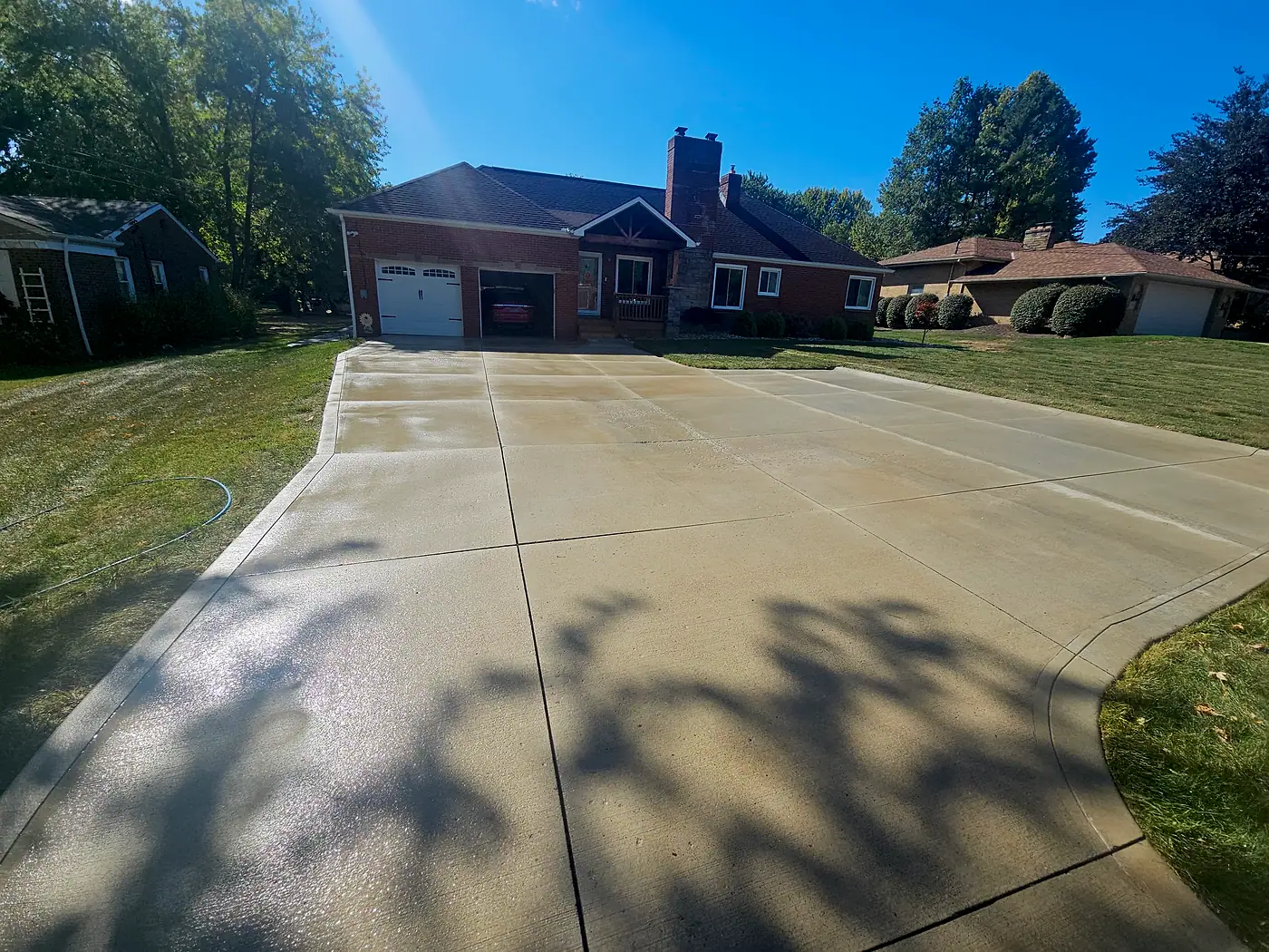Clean concrete driveway leading to a brick ranch home