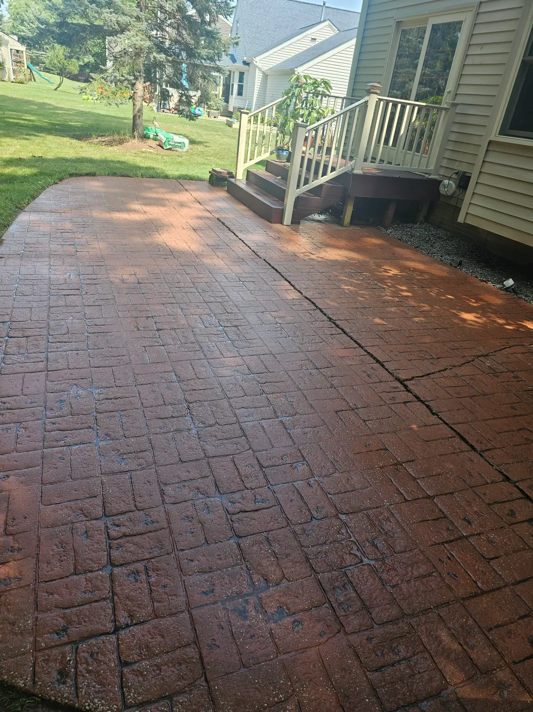 After: Red stamped concrete patio before and after cleaning