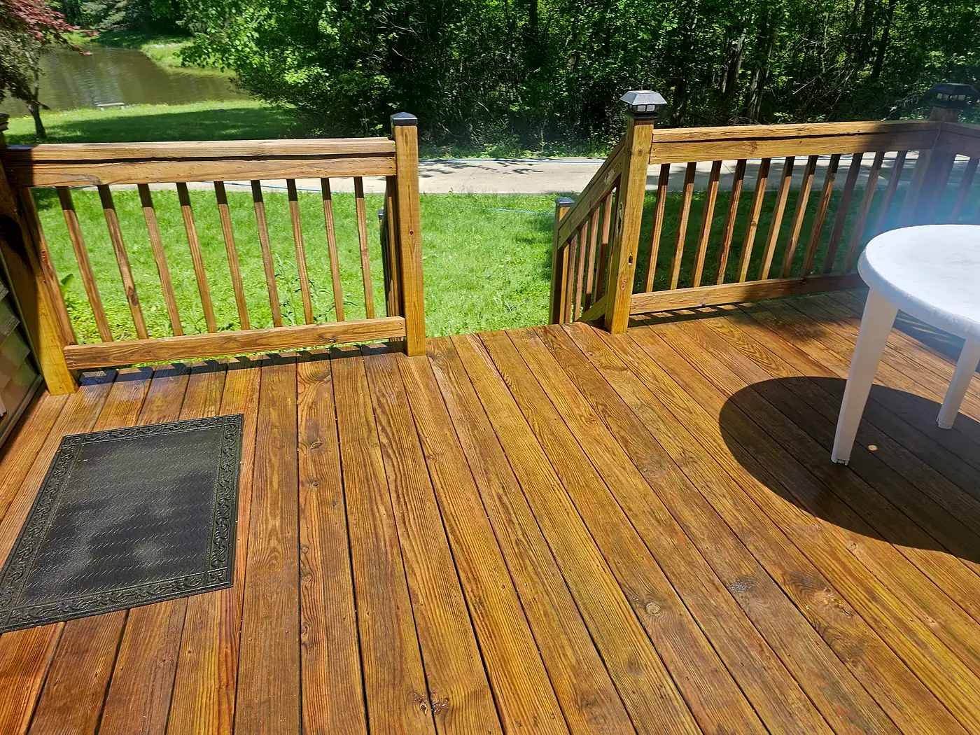 Freshly cleaned wood deck with a railing and a patio chair