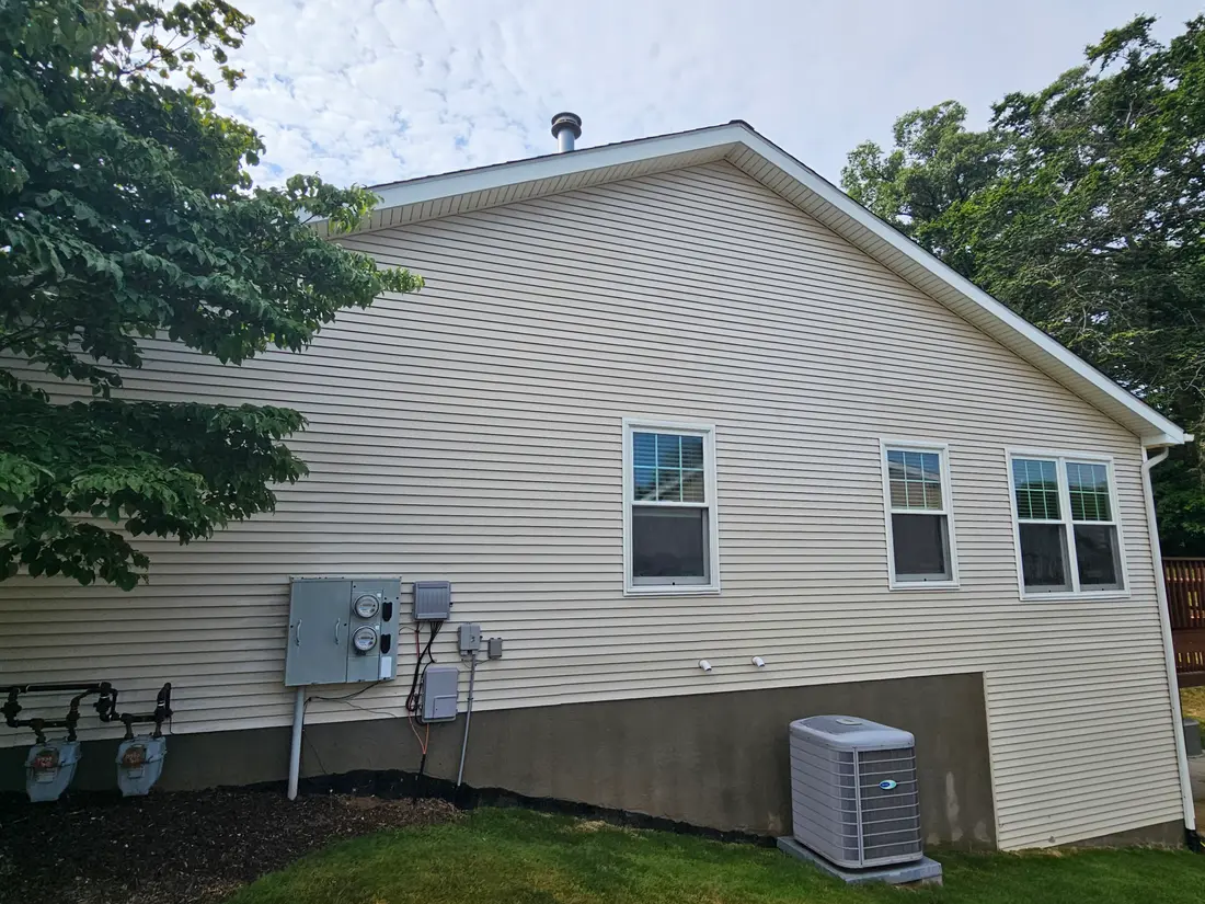After: Algae-stained side wall of a house before and after soft washing