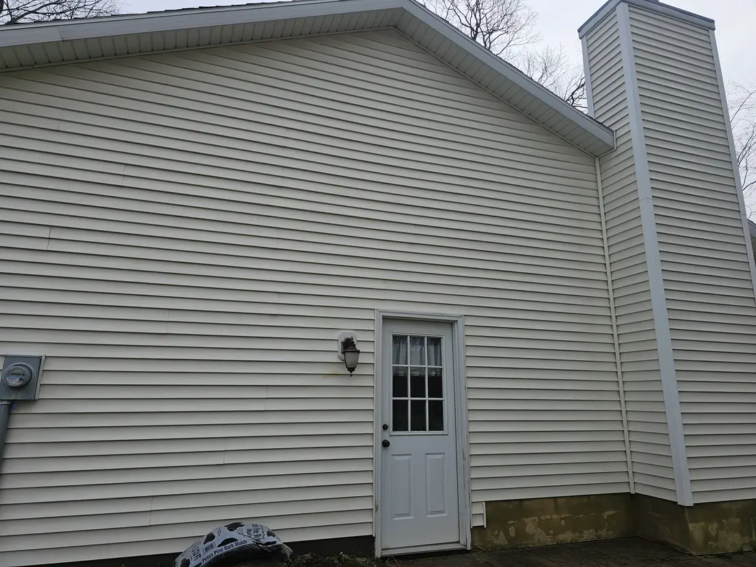After: Green-streaked siding beside a chimney before and after washing