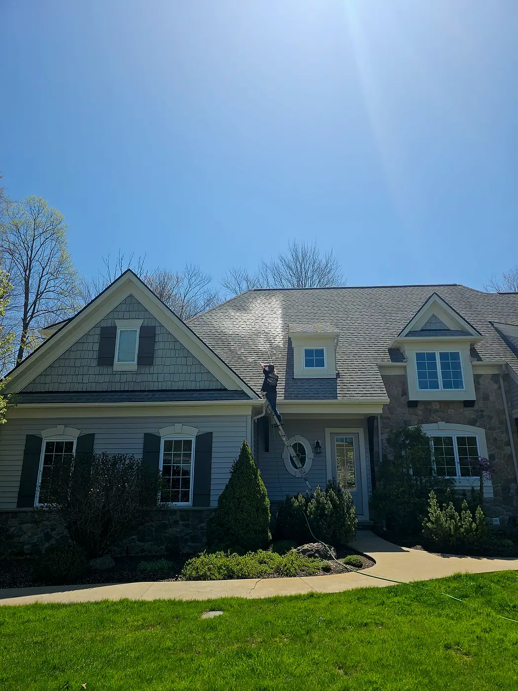 Large two-story home with dormer windows on a sunny day