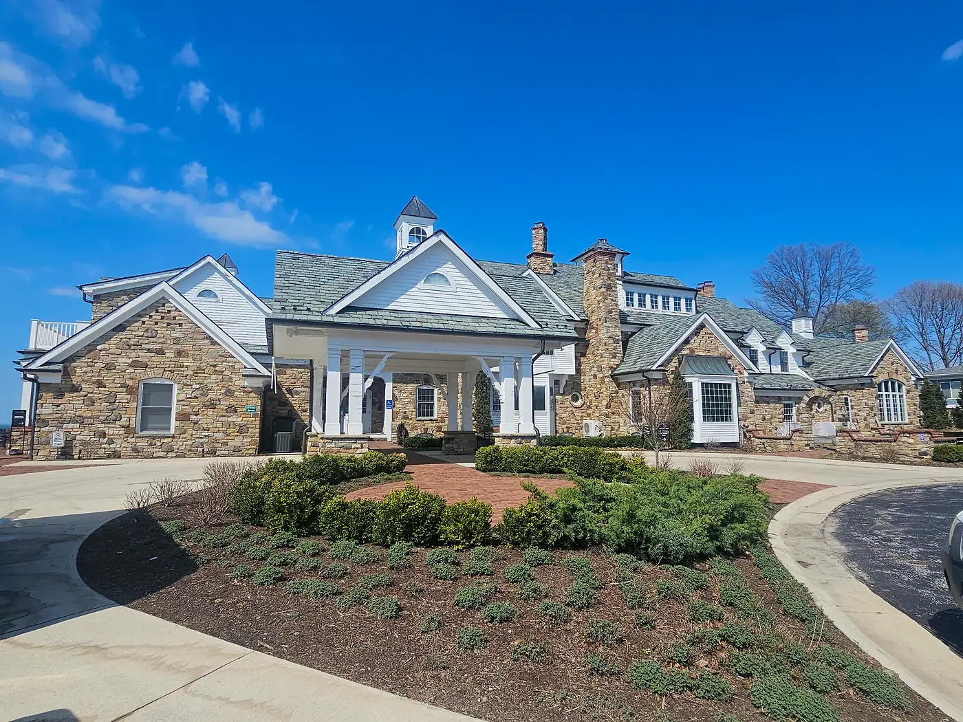 Stone and white-trim winery building with a columned entry and circular drive in Madison